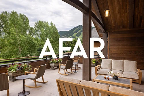 AFAR logo on a balcony with outdoor furniture and mountain view.