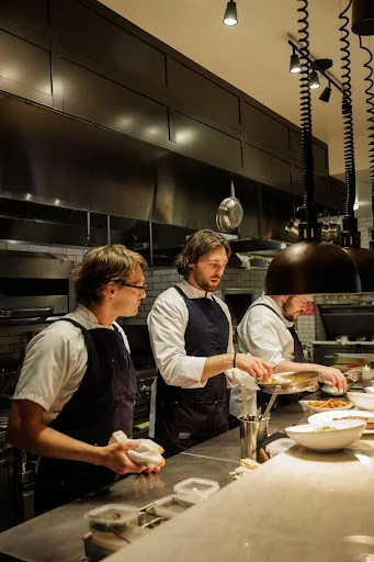 Chefs preparing dishes in a professional kitchen.
