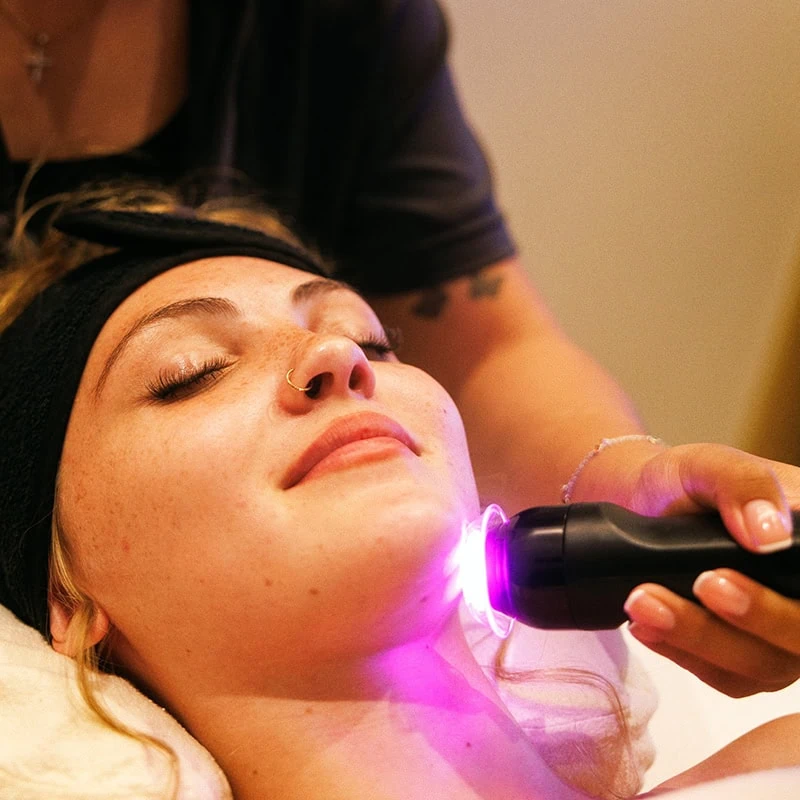 ACME Facial Treatment with LED Light Therapy on woman's face, close-up.