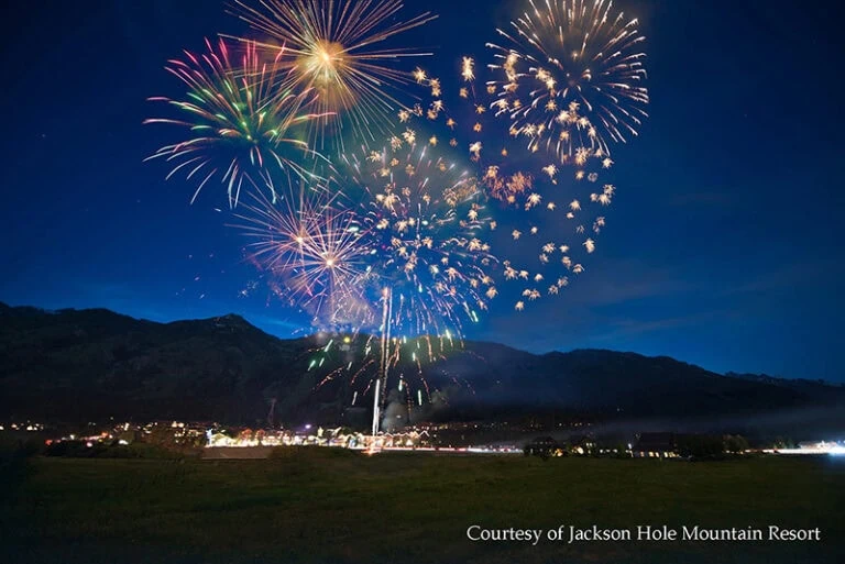 Fireworks explode over mountains during a July 4th celebration.