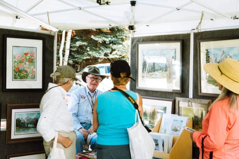 People viewing artwork at an outdoor art fair in Jackson Hole.